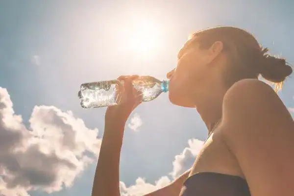 Hydration: The Secret Ingredient for a Toned Stomach and Enhanced Fitness 3 Image of woman drinking water to hydrate Falkirk after run.