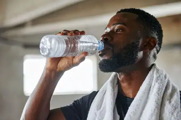Hydration: The Secret Ingredient for a Toned Stomach and Enhanced Fitness 1 Image of man drinking water to improve hydration Falkirk after work out.